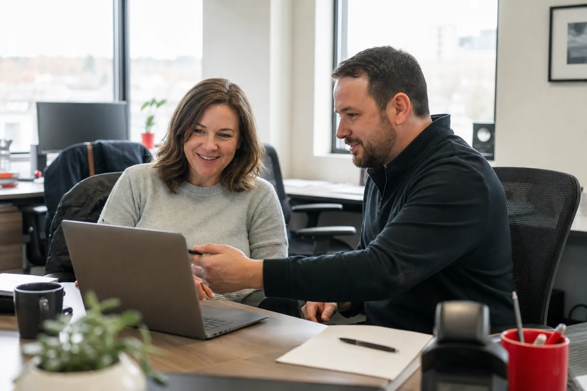 An employee and IT specialist resolving an issue together at the employee’s laptop